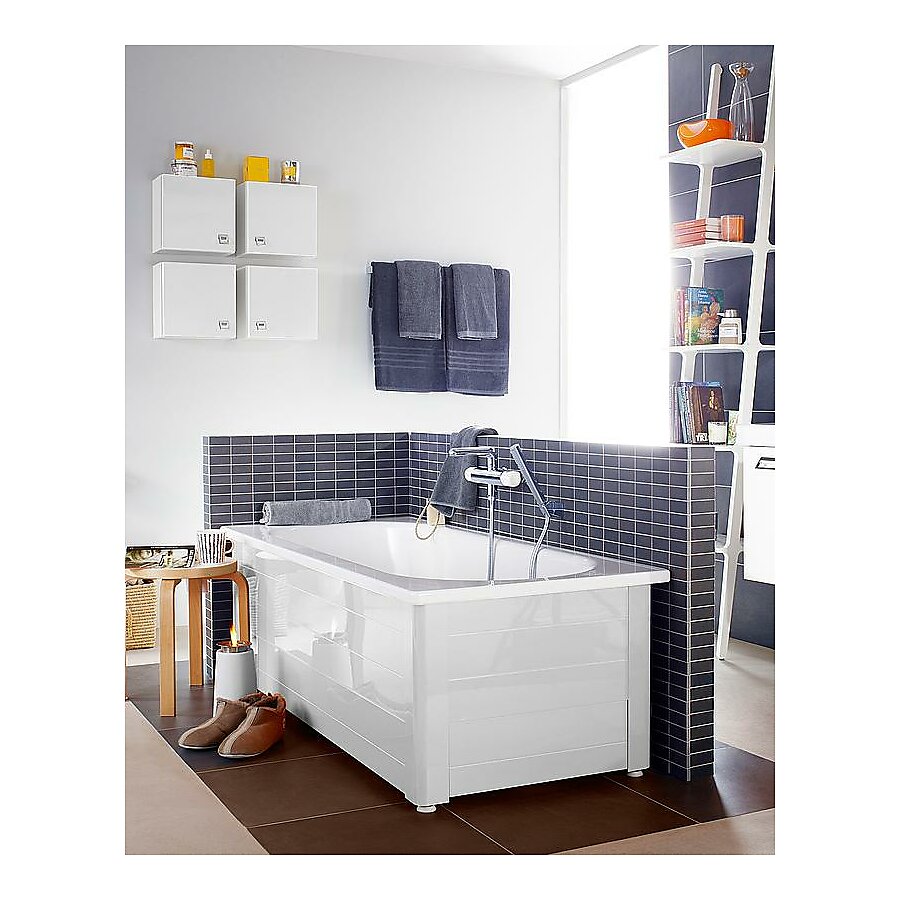 A built-in standard bathtub inside of a bathroom with tiled backsplash. 