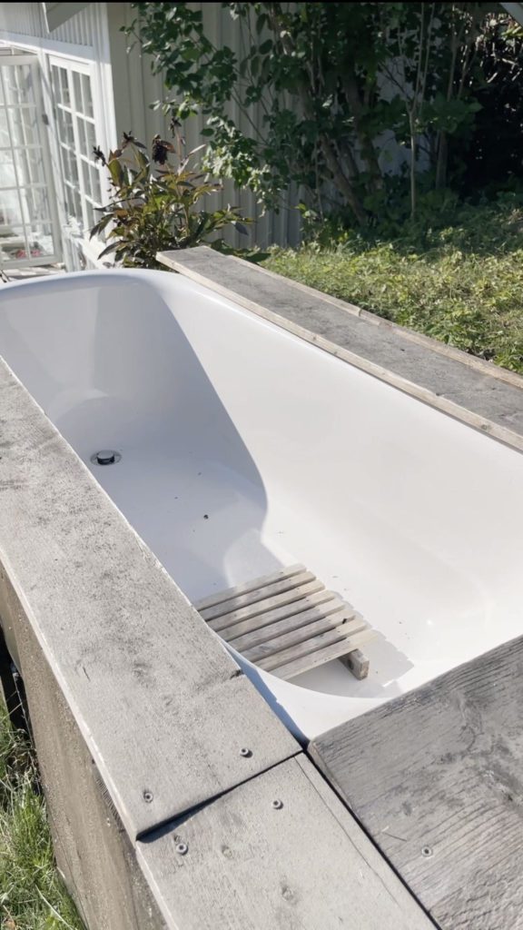 Outdoor bathtub in a tiny house garden in Norway.